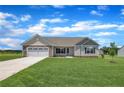 Inviting one-story home showcases a pristine lawn and classic architectural details on a bright, sunny day at 107 Camp Rock Rd, Lillington, NC 27546