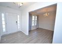 Bright entryway with wood-look floors and a view into the dining room with chandelier at 109 Red Coat Dr, Cameron, NC 28326