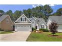 Attractive home with a well-kept lawn, lush shrubs, and a paved driveway at 15 London Way, Spring Lake, NC 28390