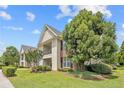 Exterior side view of an apartment building showcasing mature trees, landscaping, and a well-maintained lawn at 159 Gallery Dr # 103, Spring Lake, NC 28390