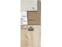 Selection of bathroom materials, including LVP flooring, bath countertop, paint samples and cabinets at 219 Uwharrie Way, Sanford, NC 27330