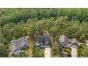 Aerial view of the home surrounded by lush greenery and neighboring properties, set in a wooded area at 25 Clearwater Hbr, Sanford, NC 27332