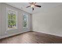 Bright bedroom featuring two windows, wood floors, a ceiling fan, and neutral paint at 25 Clearwater Hbr, Sanford, NC 27332