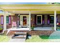 Charming front porch with brick facade, rocking chairs, and a 'Welcome' message for guests at 3897 Olivia Rd, Sanford, NC 27332