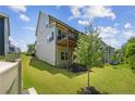 View of the home's backyard, featuring a small balcony and grassy lawn at 405 Gilpin Way, Cary, NC 27519