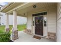 Inviting covered front porch featuring stone accents and a decorative wreath on a dark wood door at 453 Falls Creek Dr Dr, Spring Lake, NC 28390