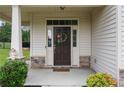Close-up of the home's entryway, showcasing a decorative wreath and stone accents on the porch columns at 453 Falls Creek Dr Dr, Spring Lake, NC 28390