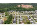 Aerial view of a residential neighborhood with tree-lined streets and a new development in the distance at 841 Golden Horseshoe Ln, Sanford, NC 27330