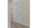 Close-up of a white front door with sidelights and neutral-colored walls, creating a bright entrance at 841 Golden Horseshoe Ln, Sanford, NC 27330