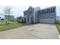Attractive two-story home with gray siding, a well-maintained lawn, and attached two-car garage at 96 Cutty Way, Lillington, NC 27546