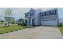 Beautiful two-story home featuring gray siding, a two-car garage, and a well-manicured lawn at 96 Cutty Way, Lillington, NC 27546