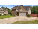 Charming two-story home features a brick facade, attached two-car garage, and manicured landscaping at 106 Linden Rd, Cameron, NC 28326