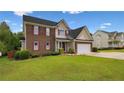 Beautiful two-story home with brick accents, red shutters, attached garage and well-maintained lawn at 106 Linden Rd, Cameron, NC 28326