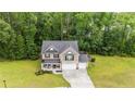 Aerial view showcasing the home's roof, surrounding trees, well-kept lawn, and spacious driveway at 446 Birch Ave, Spring Lake, NC 28390