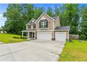 Attractive two-story home featuring a spacious driveway and lush, green surrounding landscape at 446 Birch Ave, Spring Lake, NC 28390