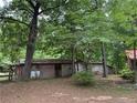 Rustic outbuilding with wooden siding, nestled amongst mature trees at 467 Deep River Rd, Sanford, NC 27330