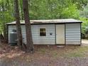 Practical metal shed with a single door and propane tank, great for extra storage on the property at 467 Deep River Rd, Sanford, NC 27330