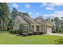 Beautiful home featuring lush landscaping, mature trees, and an attached two-car garage at 71 Orchard Falls Dr, Spring Lake, NC 28390