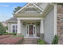 Home's entryway shows a brick walkway, front door, porch with posts, and stone accents at 71 Orchard Falls Dr, Spring Lake, NC 28390