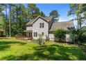 A view of the back of the home featuring a wooden deck and well-maintained lawn with mature trees at 120 Forest Pond Rd, Cameron, NC 28326