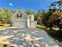 A spacious driveway leading to a two-car garage, with mature trees and landscaping surrounding the house at 147 Sherwood Ln, Sanford, NC 27332