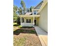 A cozy front porch with white railings and landscaping, offering a warm welcome to this charming home at 147 Sherwood Ln, Sanford, NC 27332