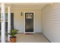 Inviting front porch featuring a stylish door, black fixtures, house numbers and attractive decor at 152 Goose Creek Cir, Dunn, NC 28334