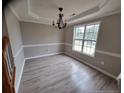 Elegant dining area with a stylish chandelier and natural light from a large window at 19 Ribbon Oak Ct, Sanford, NC 27332