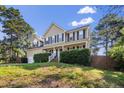 Inviting two-story home with lush greenery, dormers and a classic columned front porch at 40 Union Cir, Lillington, NC 27546