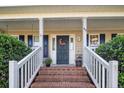 Front porch with painted railings, brick stairs, a floral wreath, and the house number displayed at 40 Union Cir, Lillington, NC 27546