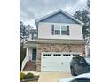 Charming two-story home featuring a stone facade, a well-manicured lawn, and an attached two car garage at 50 Teal Dr, Youngsville, NC 27596