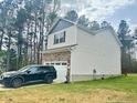 Two-story home featuring stone accents, a two car garage, and lush greenery at 50 Teal Dr, Youngsville, NC 27596