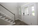 Bright foyer featuring a staircase with carpeted steps and a stylish front door with sidelights at 576 Executive Dr, Lillington, NC 27546