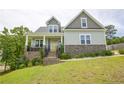 Inviting two-story home with a welcoming front porch, stone accents, and a bright yellow front door at 576 Executive Dr, Lillington, NC 27546