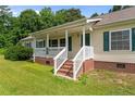 Home features a brick foundation, covered front porch with white railing and steps at 2901 Cheshire Dr, Sanford, NC 27332