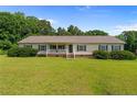 Charming ranch style home features a covered front porch, green lawn, and mature trees at 2901 Cheshire Dr, Sanford, NC 27332