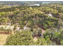 Scenic aerial shot capturing a residential area surrounded by lush green forests and the tranquil waters of a distant lake at 6138 St Andrews Dr, Sanford, NC 27332