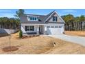 Traditional-style home with a two-car garage, covered front porch, and landscaping at 91 Laramie Ln, Selma, NC 27576