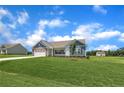 A single-story home featuring a two-car garage on a lush green lawn with blue sky and clouds overhead at 127 Camp Rock Rd, Lillington, NC 27546