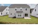 Back of house with gray vinyl siding, well-maintained lawn, and sliding glass door at 136 Camp Rock Rd, Lillington, NC 27546