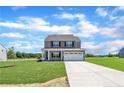 Inviting two-story home with neutral siding, a two-car garage and lawn at 136 Camp Rock Rd, Lillington, NC 27546