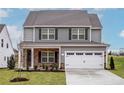 Charming two-story home with stone accents, two-car garage and well-manicured front lawn at 136 Camp Rock Rd, Lillington, NC 27546