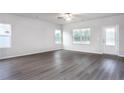Bright living room featuring wood-look floors, white walls and trim, ceiling fan, and windows offering natural light at 155 Camp Rock Rd, Lillington, NC 27546