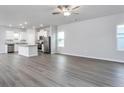 Open floor plan with wood-look floors, white walls, and white kitchen with stainless steel appliances and granite countertops at 155 Camp Rock Rd, Lillington, NC 27546