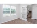Home office area with carpet, a staircase in view and natural light from the windows at 158 Camp Rock Rd, Lillington, NC 27546