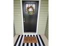 A welcoming front door is adorned with a floral wreath and a cheerful 