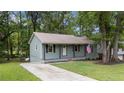 Cozy one-story home with a covered front porch, a well-manicured lawn, and mature trees at 2308 Keith Dr, Raleigh, NC 27610