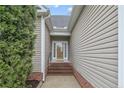 View of the entryway with brick steps leading up to the light-filled front door and neutral siding at 45 Remington Hills Dr, Bunnlevel, NC 28323