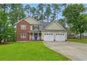 Charming two-story brick and siding home featuring a well-maintained lawn, two-car garage, and blue front door at 46 Wateredge Ln, Sanford, NC 27332