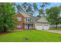 Charming two-story brick and siding home featuring a well-maintained lawn, two-car garage, and blue front door at 46 Wateredge Ln, Sanford, NC 27332